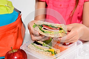 Child removing wholemeal sandwich out of lunchbox