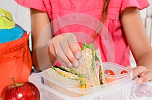 Child removing wholemeal sandwich out of lunchbox