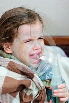 Child with respiratory illness making inhalation with inhaler.