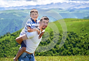 a child rides on his father's back