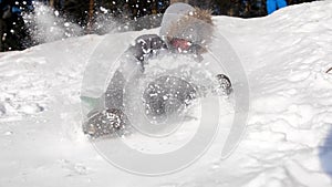 A child rides and plays on a snowy mountain. Slow motion. Snowy winter landscape. Outdoor sports