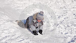 A child rides and plays on a snowy mountain. Slow motion. Snowy winter landscape. Outdoor sports