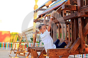 The child rides on a swing in the playground.