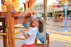 The child rides on a swing in the playground.