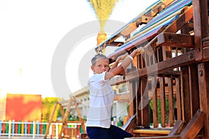 The child rides on a swing in the playground.