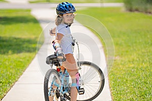 Child riding bicycle. Little kid boy in helmet on bicycle along bikeway. Happy cute little boy riding bicycle. Child in