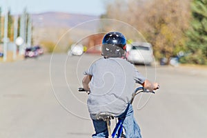 Child riding a bike with helmet.