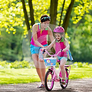 Mother teaching child to ride a bike