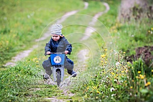 Child riding bike through a puddle creating a splash
