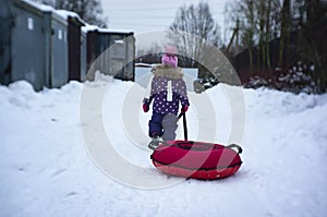 A child is riding a cheesecake with a snowy hill