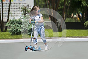 Child riding scooter. Kid on colorful kick board. Active outdoor fun for kids. Summer sports for preschool children