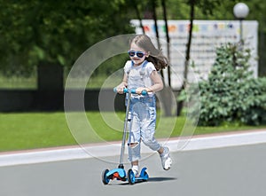 Child riding scooter. Kid on colorful kick board. Active outdoor fun for kids. Summer sports for preschool children