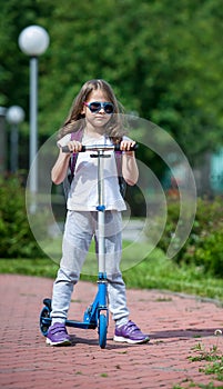 Child riding scooter. Kid on colorful kick board. Active outdoor fun for kids. Summer sports for preschool children