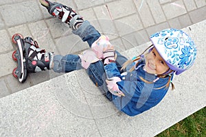 Child with roller skates and protective helmet