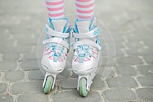 The child is rollerblading. Girl in pink tights. Childhood and hobby concept