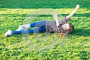 Child rolling down hill in grass