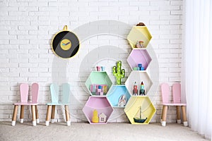 Child room interior with colorful shelves near brick wall