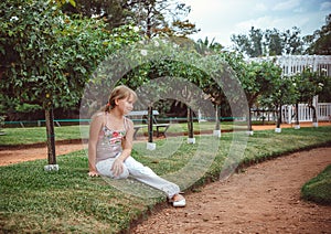 Child with rose flower in spring garden