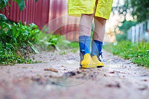 Child in rubber boots walking . child`s feet in a rubber boot