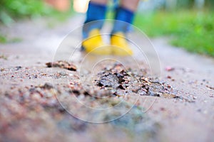 Child in rubber boots walking . child`s feet in a rubber boot