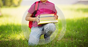 Child with rucksack sitting in the park near school