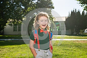 Child with rucksacks in the school park. Pupils with backpacks outdoors. Funny nerd kid.