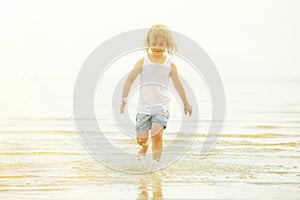 Child running beach shore splashing water
