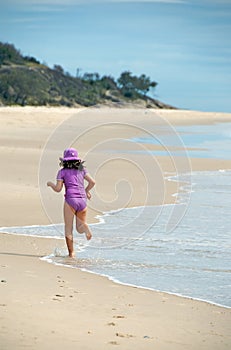 Child running on exotic beach photo