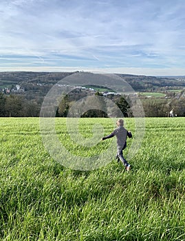 Child running on green field