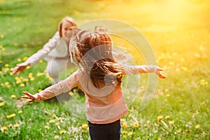 Child running into mother`s hands to hug her. Family having fun in the park. photo