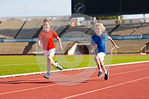 Child running in stadium. Kids run. Healthy sport photo