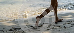 A child runs along the river bank splashing water with his feet. In summer, the child plays on the beach, runs barefoot on the
