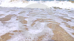 A child runs along the waves. Macro video of children`s feet that run through the sea foam. Happy childhood concept