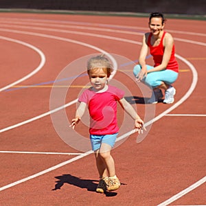 Child runs away from mom at the stadium.