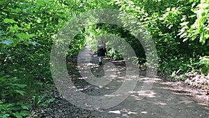 A child runs through the forest and throws out his toy.