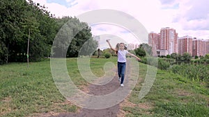 Child runs with a paper plane. girl in a green park, forest