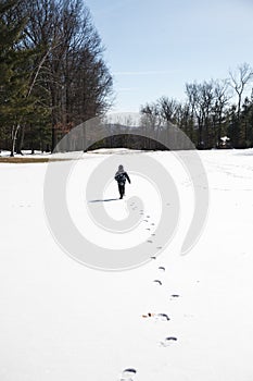 The child runs and plays in the snow