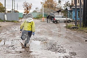 A child runs through a puddle. Children& x27;s clothing