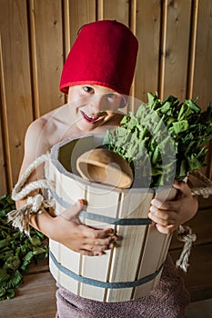 Child in a Russian bath with a birch broom