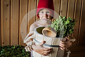 Child in a Russian bath with a birch broom