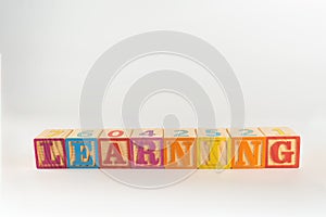 A child`s alphabet toy spelling word block set, spelling out the word learning