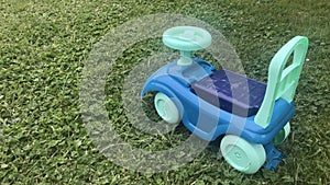 Child`s bike. A blue ride-on toy car on a grass field.