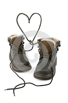 Child's boots form a heart with shoelaces. photo