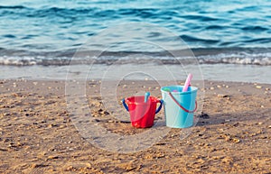 Child`s bucket, spade and other toys on empty beach