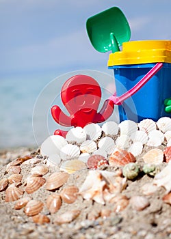 Child's bucket, spade and other toys on tropical beach against b