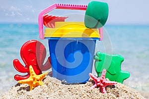 Child's bucket, spade and other toys on tropical beach against b