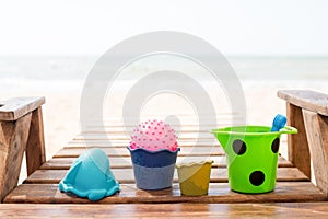 Child`s bucket, spade and other toys on tropical beach against blue sky