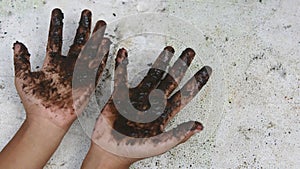 child& x27;s dirty hands. black mud on the palms with blur background