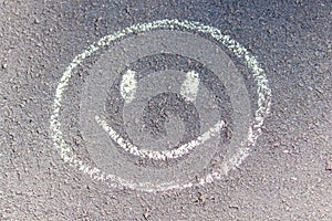 Child`s drawing of a smile on asphalt. Good day with good moon.