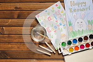 A child`s drawing on the theme of Easter: egg, Bunny, congratulation with Easter. The view from the top, paints, pencils, brush a